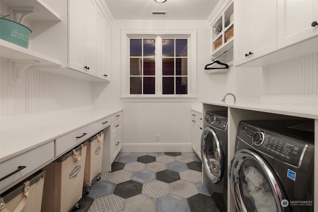 laundry area featuring independent washer and dryer, tile floors, and cabinets