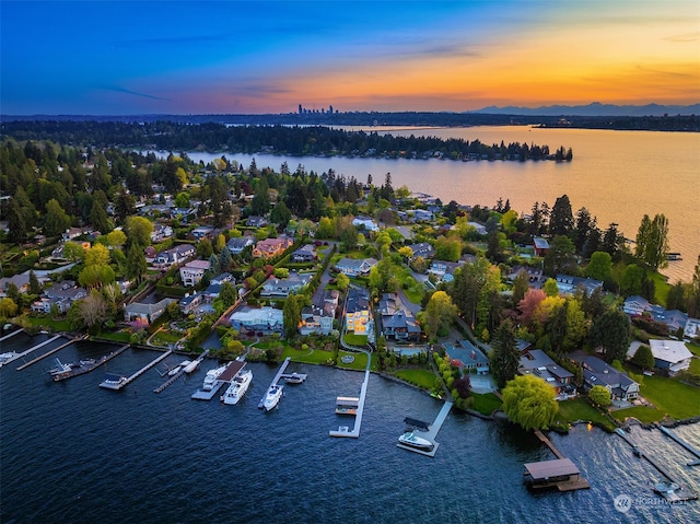 aerial view at dusk featuring a water view