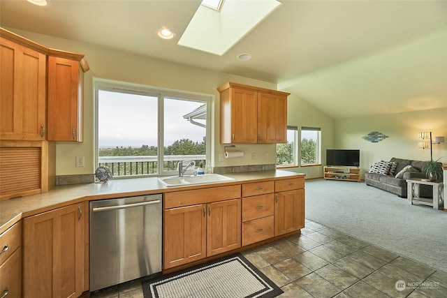 kitchen featuring sink, light carpet, dishwasher, and lofted ceiling with skylight