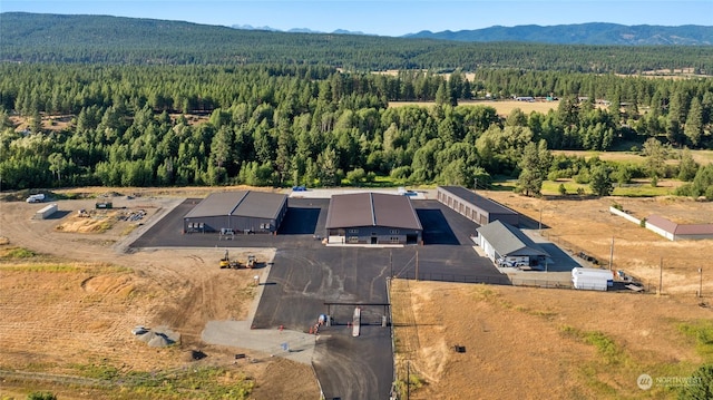 aerial view featuring a wooded view and a mountain view