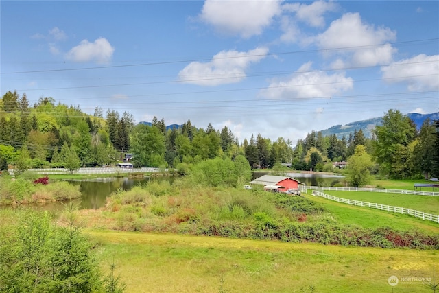 surrounding community featuring a rural view, a yard, and a water view