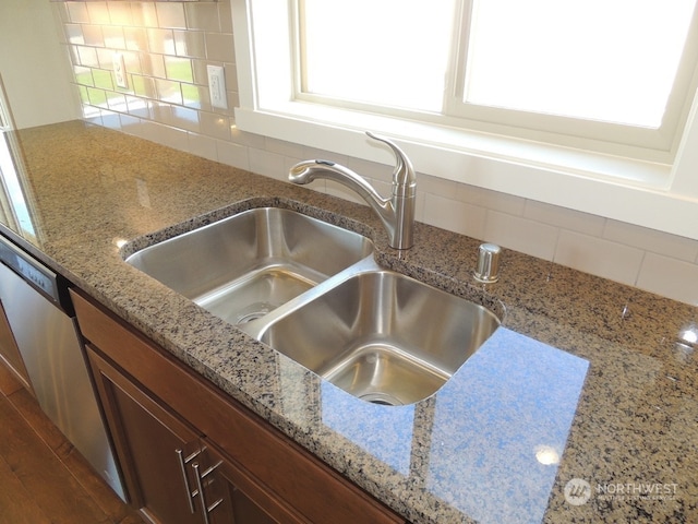 room details featuring light stone counters, sink, and backsplash