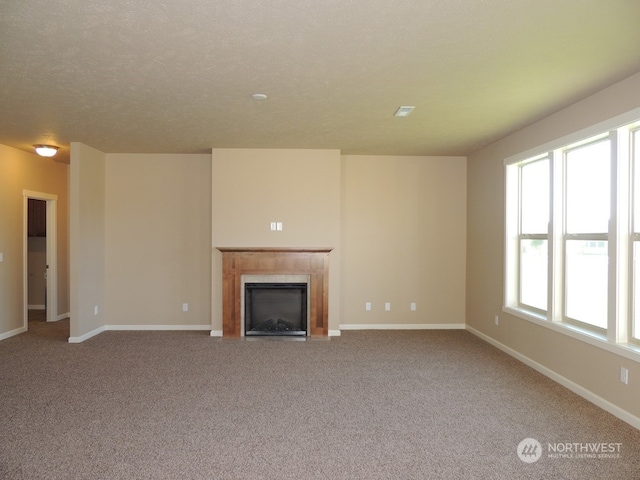 unfurnished living room with light colored carpet and a textured ceiling