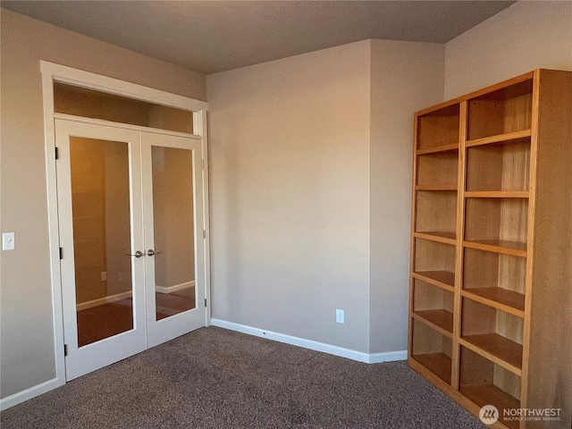 unfurnished bedroom featuring dark carpet and french doors