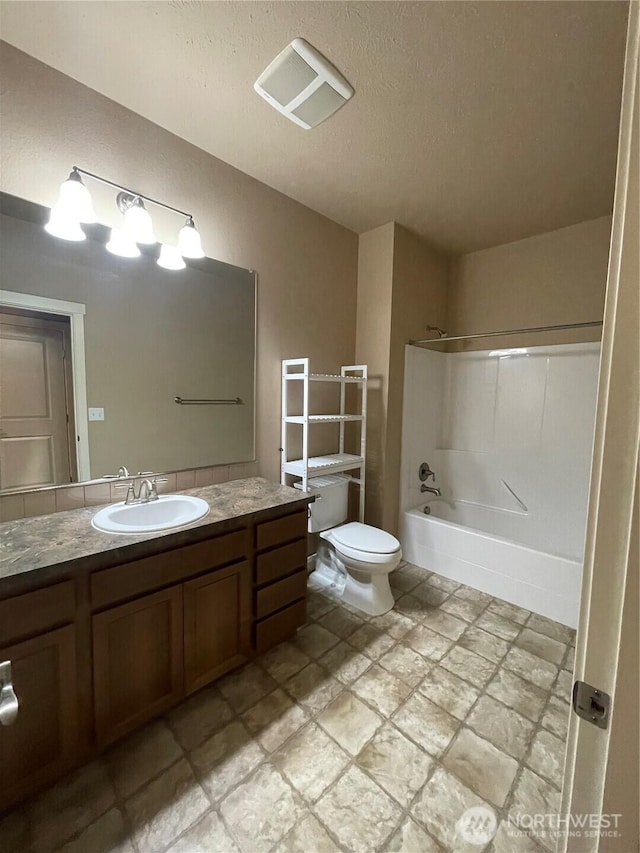 full bathroom with washtub / shower combination, vanity, toilet, and a textured ceiling