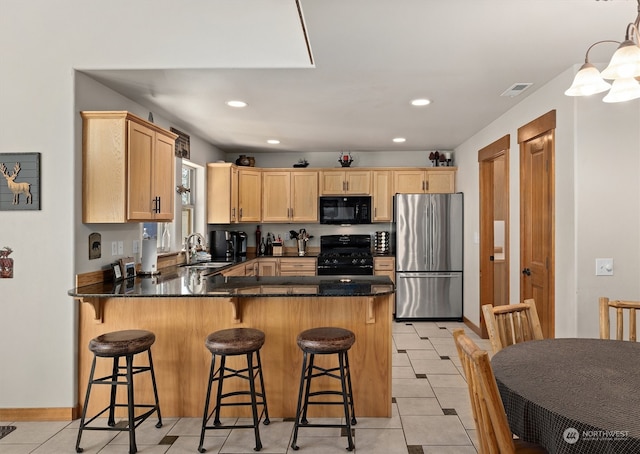 kitchen with range, light brown cabinetry, stainless steel refrigerator, light tile flooring, and kitchen peninsula