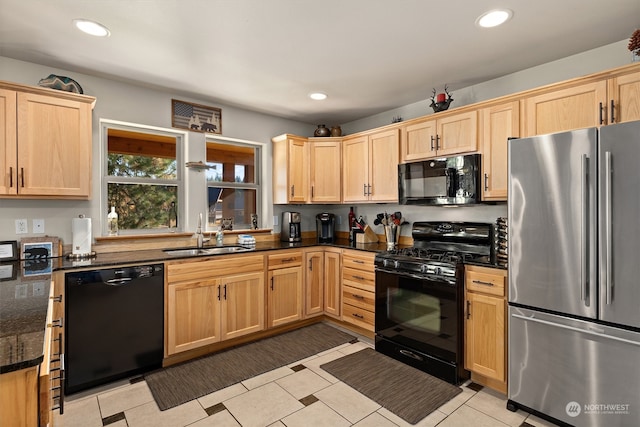 kitchen featuring sink, dark stone countertops, light tile floors, and black appliances