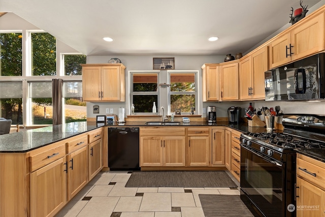 kitchen with dark stone countertops, light tile floors, sink, black appliances, and kitchen peninsula