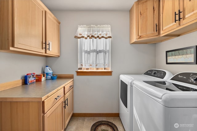 laundry room with cabinets, washing machine and dryer, and light tile floors