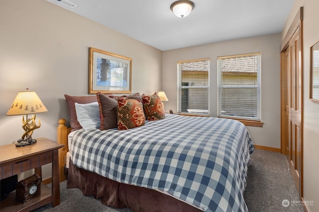 bedroom with a closet and dark colored carpet