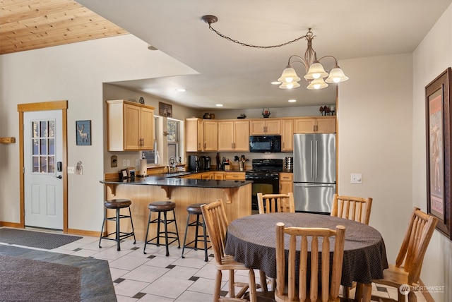 kitchen featuring kitchen peninsula, light brown cabinets, black appliances, and light tile floors