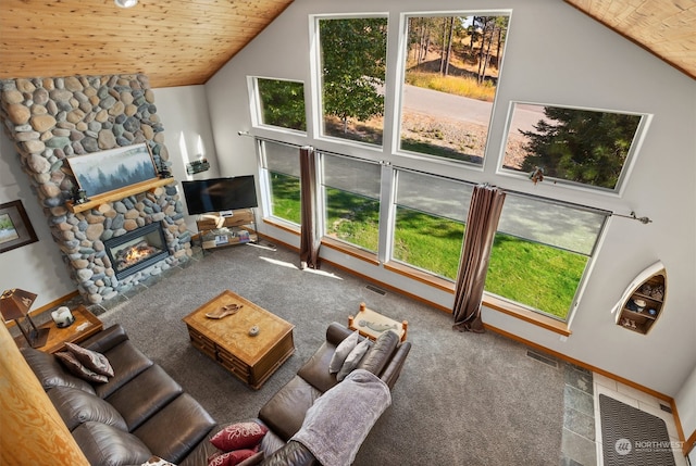 carpeted living room with wood ceiling, a stone fireplace, and high vaulted ceiling