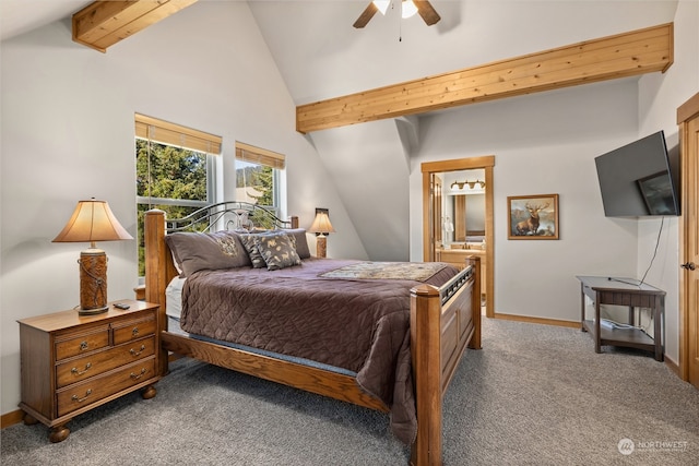 bedroom with ceiling fan, dark carpet, vaulted ceiling with beams, and connected bathroom