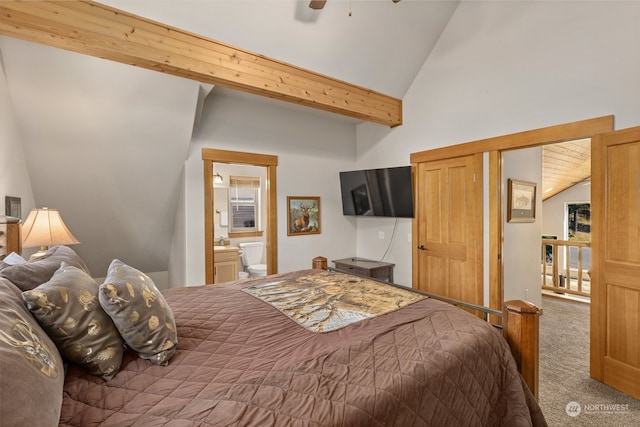 carpeted bedroom with vaulted ceiling with beams and ensuite bathroom