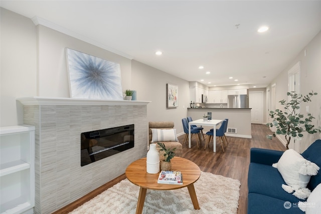 living room with a tile fireplace and hardwood / wood-style floors