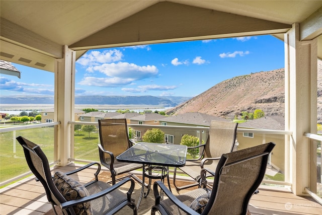 wooden terrace featuring a mountain view and a lawn