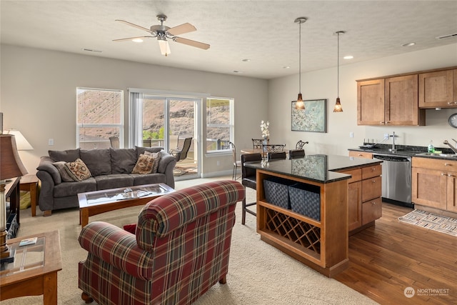 kitchen with a center island, decorative light fixtures, sink, dishwasher, and ceiling fan