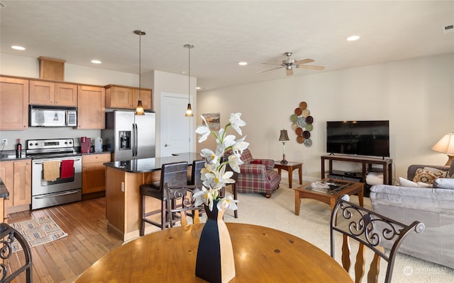 9246 Red Cliff Dr NW Unit B66, Quincy, WA 98848 - kitchen featuring ceiling fan, a center island, hanging light fixtures, stainless steel appliances, and wood-type flooring