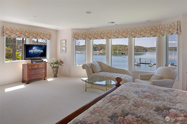 bedroom with a water view and carpet floors