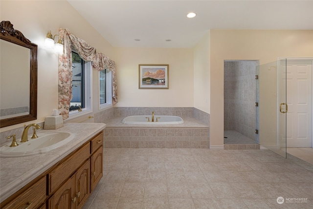 bathroom with tile floors, plus walk in shower, and vanity with extensive cabinet space