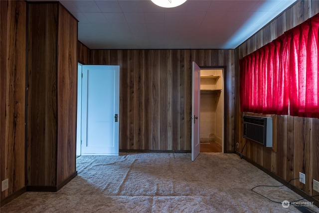 carpeted spare room featuring an AC wall unit and wooden walls