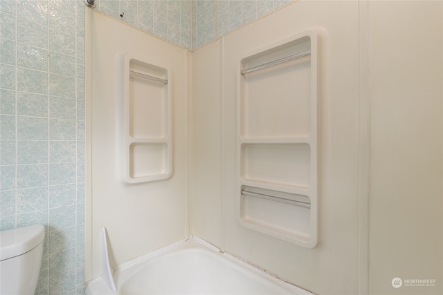 bathroom featuring tile walls,  shower combination, and toilet