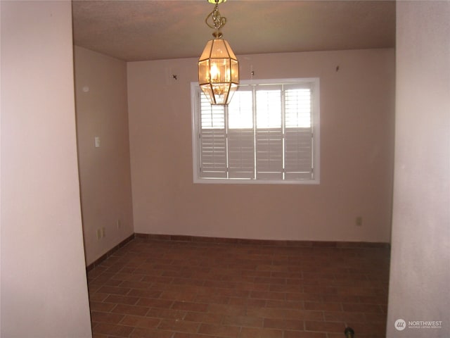 unfurnished room with a chandelier