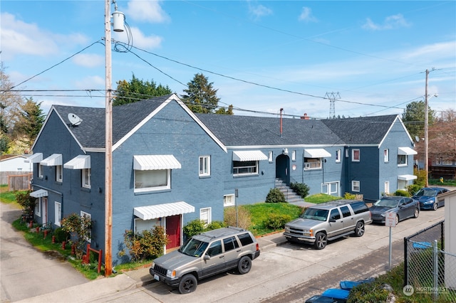 view of property featuring fence and brick siding