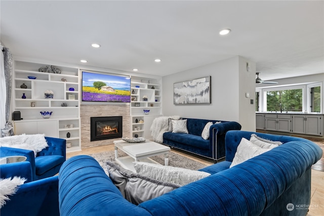 living room featuring ceiling fan and built in shelves