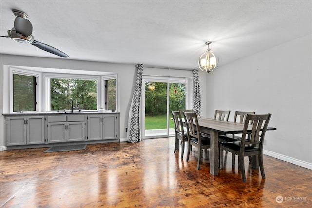 dining room with ceiling fan with notable chandelier and sink