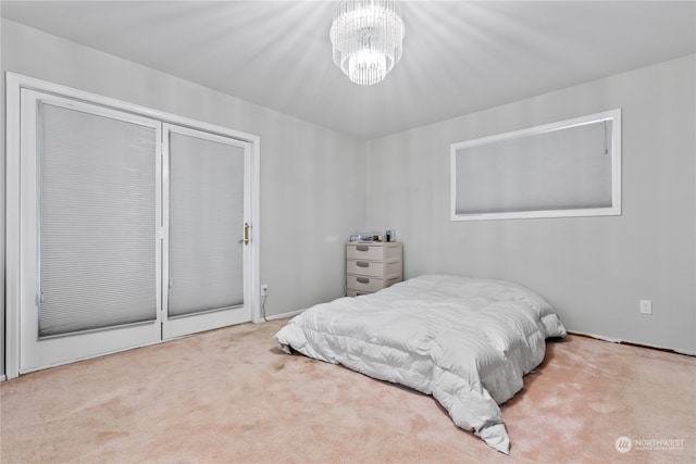 carpeted bedroom featuring a chandelier