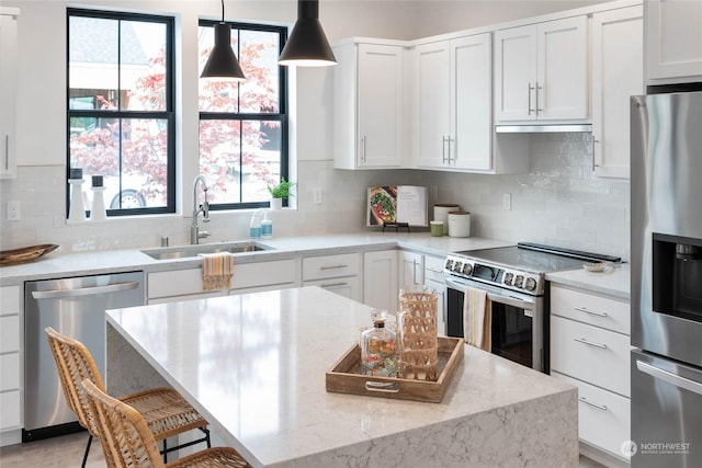 kitchen featuring decorative light fixtures, sink, tasteful backsplash, appliances with stainless steel finishes, and white cabinets