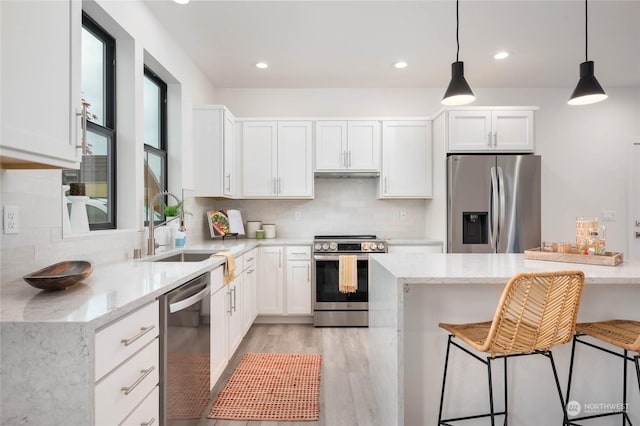 kitchen with appliances with stainless steel finishes, white cabinets, and light stone countertops