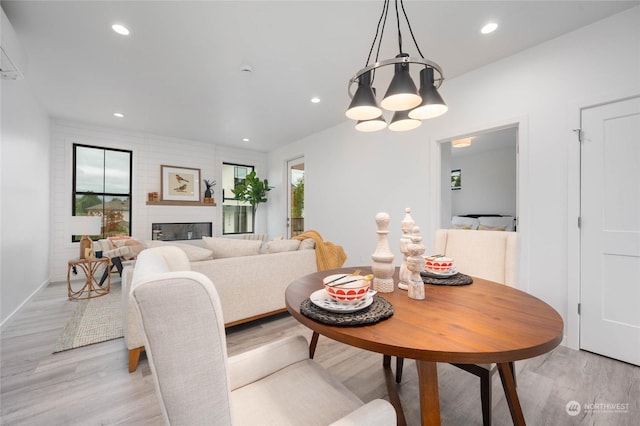 dining room with a fireplace and light wood-type flooring