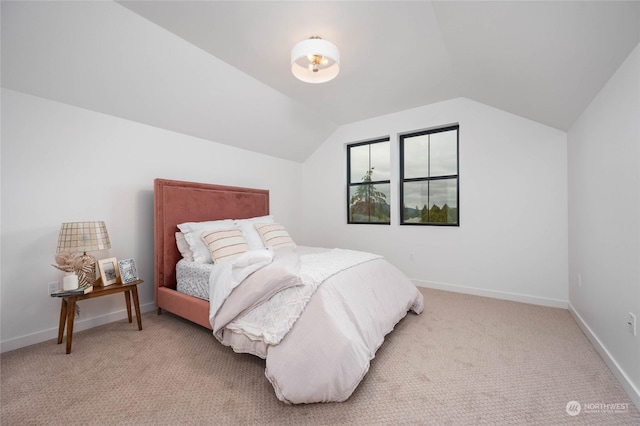 bedroom with vaulted ceiling and light carpet