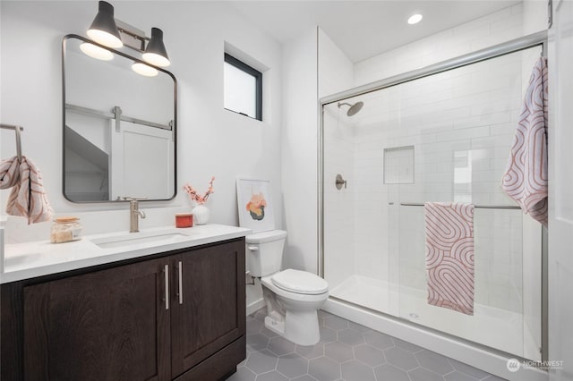 bathroom featuring toilet, vanity, and a shower with door