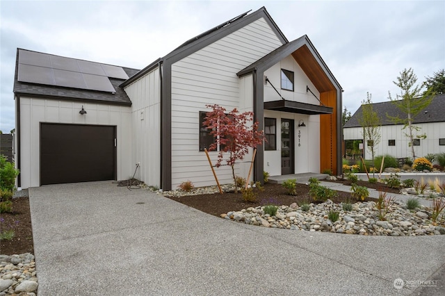 view of front facade featuring a garage and solar panels