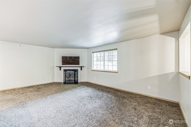 unfurnished living room with carpet flooring and a fireplace