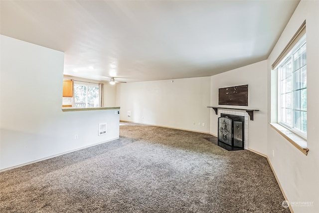 unfurnished living room featuring carpet floors and ceiling fan