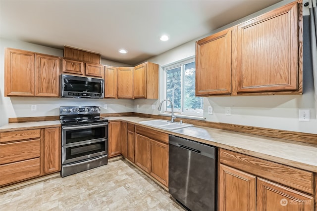 kitchen featuring sink, light tile floors, and stainless steel appliances