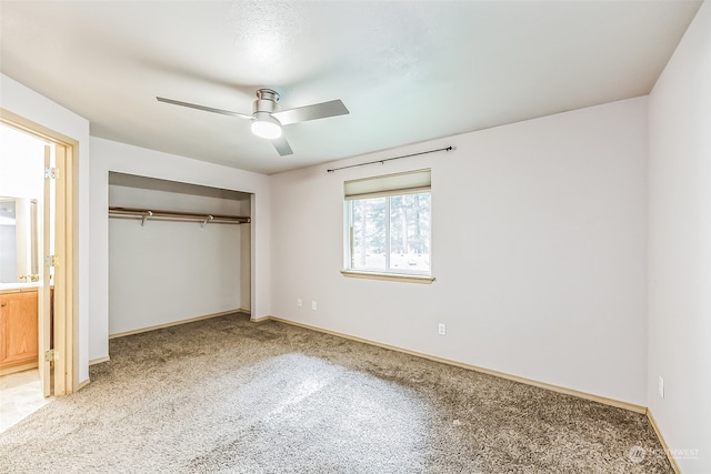 unfurnished bedroom featuring a closet, ceiling fan, ensuite bath, and carpet floors