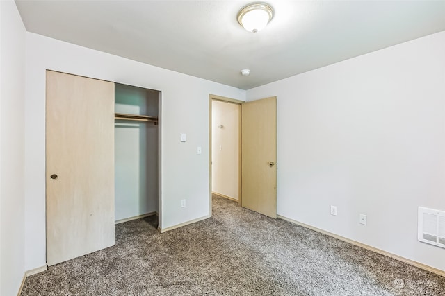 unfurnished bedroom featuring a closet and dark carpet