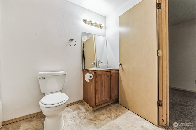 bathroom with toilet, tile flooring, and vanity