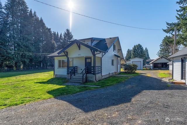 view of front of house with a garage, a front lawn, and an outdoor structure