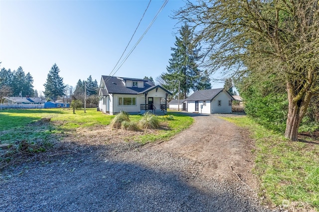 view of front of property with a garage, a front lawn, and an outdoor structure