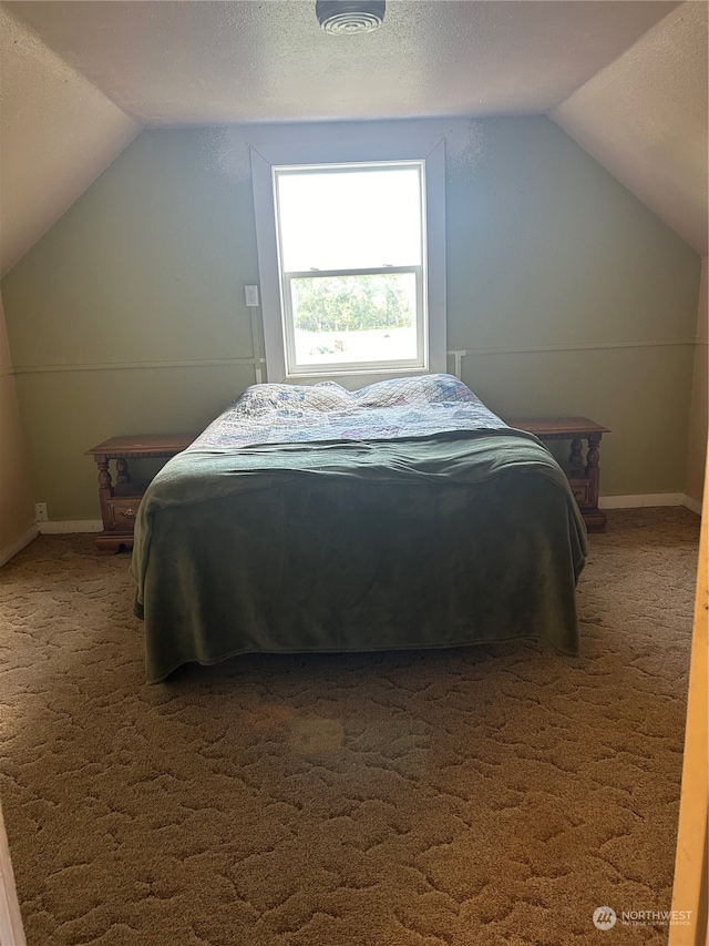 carpeted bedroom with a textured ceiling and lofted ceiling