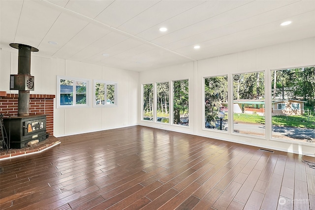 interior space with a wood stove and dark hardwood / wood-style flooring