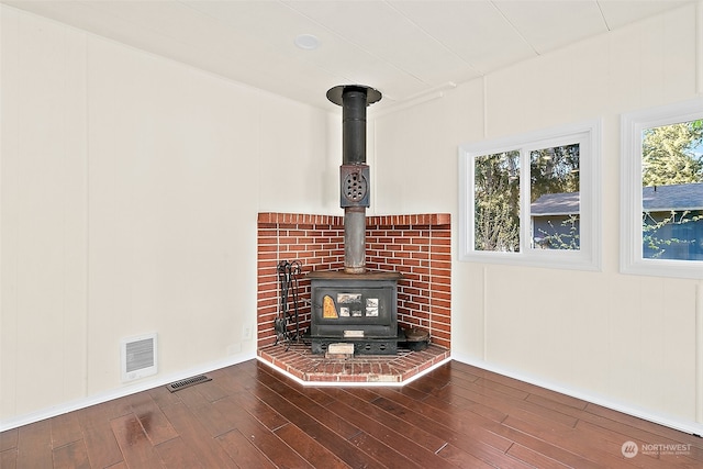 room details with a wood stove and hardwood / wood-style floors