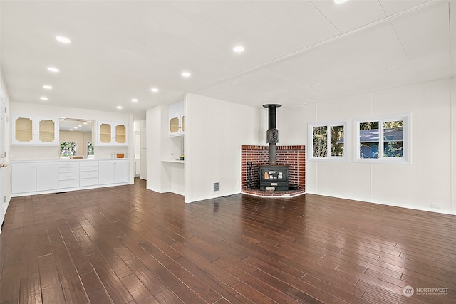 unfurnished living room featuring a wood stove and dark hardwood / wood-style floors