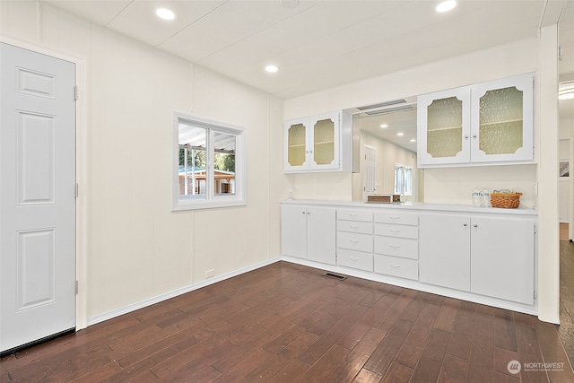 interior space with white cabinets and hardwood / wood-style floors